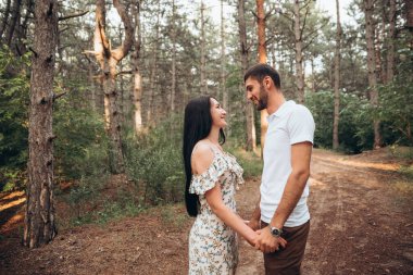 Neşeli çift doğal arka planda birbirine sarılıyor. Kırsalda romantik bir tatil randevusu. Duygusal denge rahatlatıcı yaşam tarzı