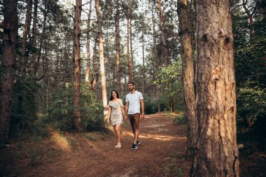 Neşeli çift doğal arka planda birbirine sarılıyor. Kırsalda romantik bir tatil randevusu. Duygusal denge rahatlatıcı yaşam tarzı