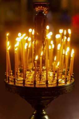 İnce sarı yanan mumlar. Kilise mumları.