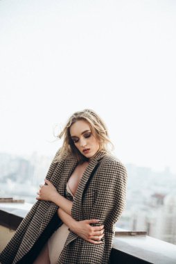 Çatıda iç çamaşırlı, uzun saçlı güzel kız.