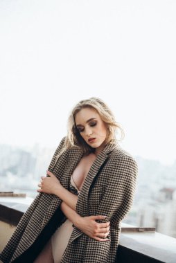 Çatıda iç çamaşırlı, uzun saçlı güzel kız.