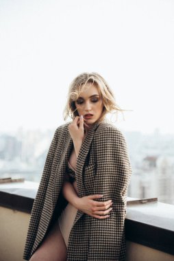 Çatıda iç çamaşırlı, uzun saçlı güzel kız.