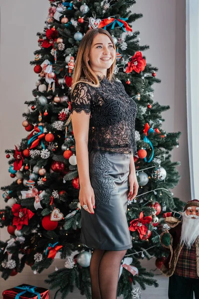 Junge schöne Frau neben einem Weihnachtsbaum mit Geschenk — Stockfoto