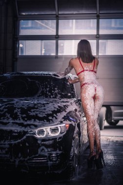 Mayolu kız arabanın kaputunda yatar ve onu yıkar.