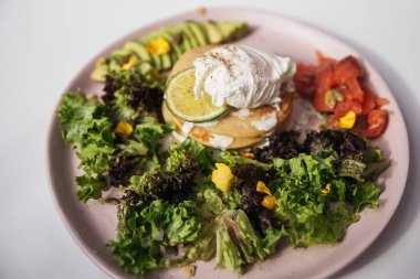 Haşlanmış yumurta, krep ve somonlu yeşil salata.