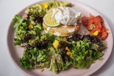 Haşlanmış yumurta, krep ve somonlu yeşil salata.