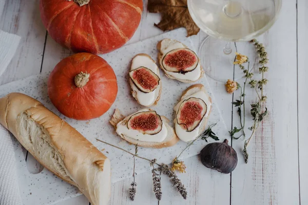 Pumpkins, baguette with ricotta and figs on a white table. Vegan, vegetarian, healthy, comfort food concept. Autumn still-life. Halloween. Harvest. Postcard — Stock Photo, Image