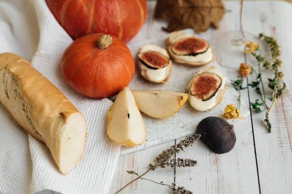 Pumpkins, baguette with ricotta and figs on a white table. Vegan, vegetarian, healthy, comfort food concept. Autumn still-life. Halloween. Harvest. Postcard — Stock Photo, Image