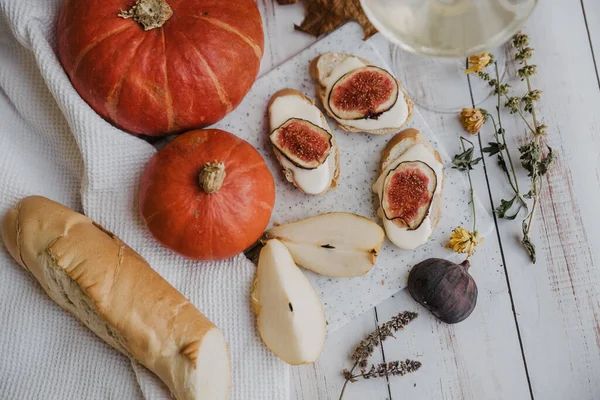 Pumpkins, baguette with ricotta and figs on a white table. Vegan, vegetarian, healthy, comfort food concept. Autumn still-life. Halloween. Harvest. Postcard — Stock Photo, Image