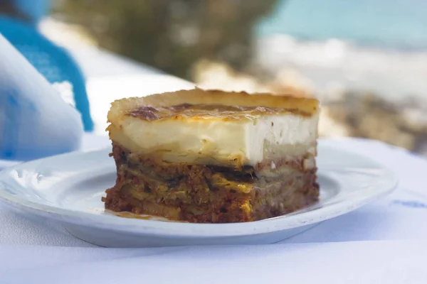 Üstünde belgili tanımlık tepe seaside, huysuz bir beşamel ile Yunan geleneksel Musakka