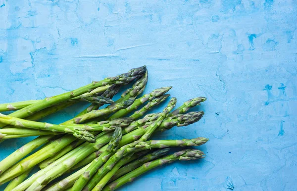 Grunge mavi zemin üzerine taze yeşil kuşkonmaz