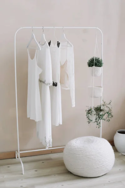 Vestidos blancos en una percha. Concepto minimalista. Conjunto de vestidos de novia de mujer en perchas de madera, fondo de moda, primer plano — Foto de Stock