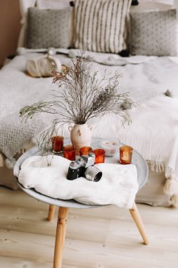 Modern ev iç tasarım. Yastık, battaniye ve başucundaki retro kamera ve mum ile yatak. Egzotik yatak odası iç, İskandinav tarzı