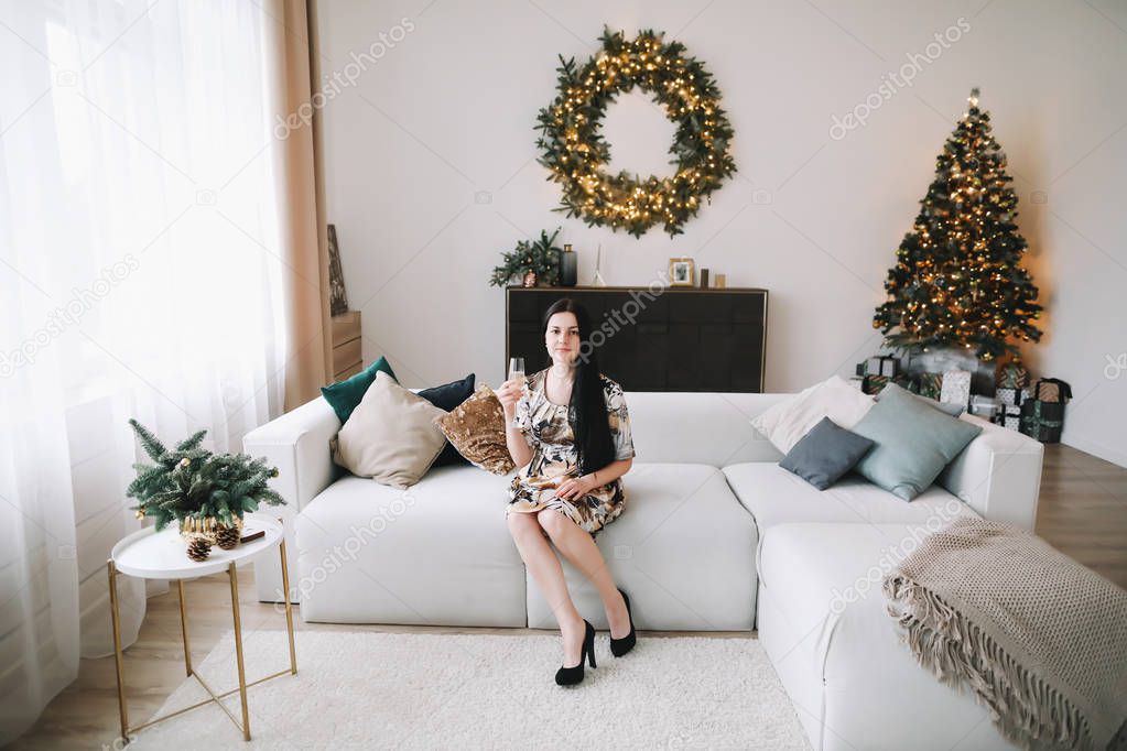 Girl with a glass of champagne in the New Year's interior. Christmas and  New Year minimal concept