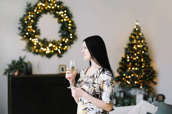 New Year's portret van een meisje met een glas champagne. Kerstmis en Nieuwjaar minimale concept — Stockfoto