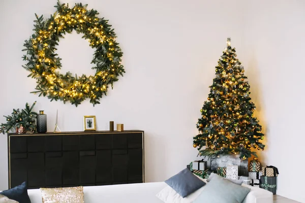 New Year\'s interior. Decorated Christmas tree with gifts. Wreath of spruce  with garland. Christmas decorations