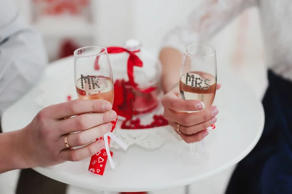 Руки жениха и невесты с кольцами, держащими бокалы с шампанским . — стоковое фото