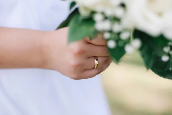 Sposa tiene un bouquet da sposa, fede nuziale, dettagli di nozze — Foto Stock