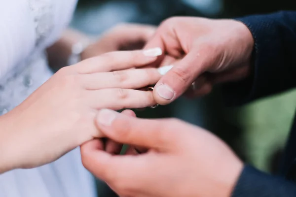 Handen van bruid en bruidegom met ringen. trouwjurk, bruiloft details — Stockfoto