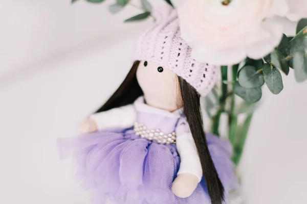 Cute doll with long brown hair in beautiful dress on white background. Decorative doll.