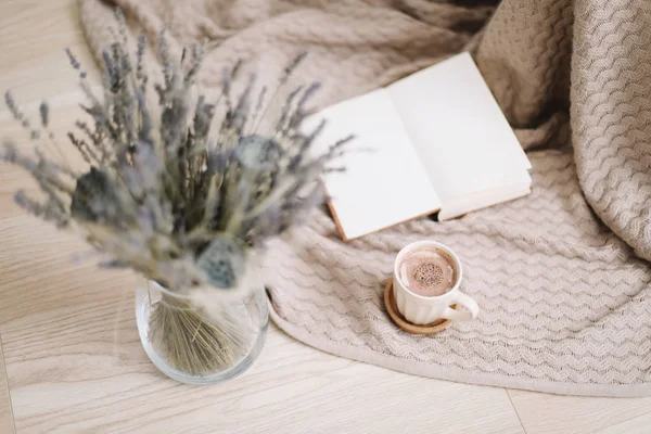 ahşap arka planda kitap ve fincan kahve ile lavanta buket. Kurutulmuş çiçekler ve kitap ile bir fincan cappuccino, bahar konsepti. üst görünüm. yatık