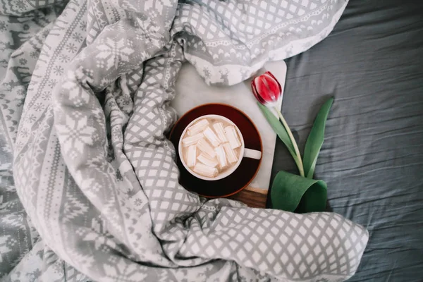 Tazza di caffè con marshmallow e tulipani rossi a letto. Concetto di vacanza, compleanno, Pasqua, 8 marzo. — Foto Stock