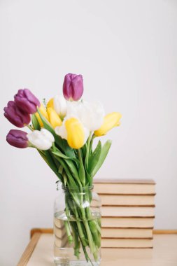 Güzel Lale buketi. Bahar lale çiçekleri karışımı. Taze bahar çiçekleri ve beyaz zemin üzerine kitaplar. 