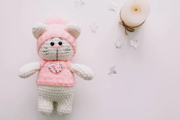 Handmade knitted toy cat on white. Hello kitty. flat lay, top view