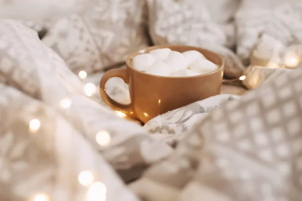 Marshmallowlu kahve fincanı. Yatakta kahvaltı. Sabah kahvesi. Beyaz yatak odası. Güzel bir ev. düz yatıyordu — Stok fotoğraf