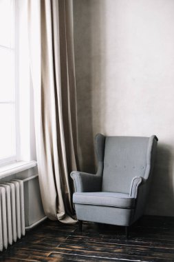 Pencerenin yanında modern bir koltuk. Bir dizi mobilya. Modern iç mekan. 
