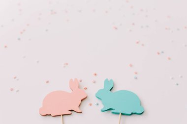 Mutlu Paskalya konsepti. Beyaz arka planda iki tavşan oyuncak. Paskalya tatili geçmişi, bahar sezonu. Tavşanlarla Paskalya dekorasyonu. Kapat, üstte görüş. kopyalama alanı