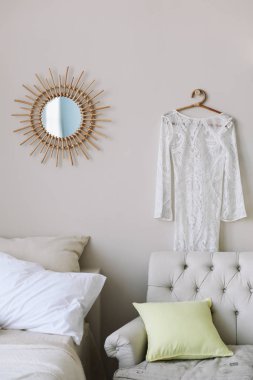 Yatak odasında asılı beyaz gelinlik. Kız dolabı. Aynanın yanında dantel elbise. 