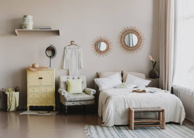 İskandinav modern rahat iç. Yatak odasında yastık, koltuk ve dekorasyon ile geniş yatak.