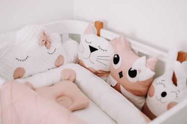 Çocuk odasının komik detayları. Bir kız bebek için tatlı kreş odası süslemeleri. Rahat beşik ile şık bebek odası iç. 