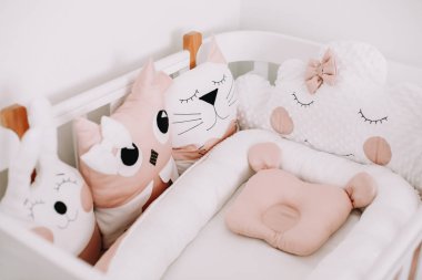 Çocuk odasının komik detayları. Yastık bulutu, kedi, tavşan. Bir kız bebek için tatlı kreş odası süslemeleri. Şık bebek beşiği.