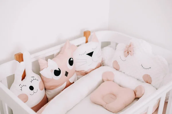 Elegante interior de la habitación del bebé con cuna cómoda. Acogedora habitación infantil de estilo escandinavo con almohadas decorativas de colores . —  Fotos de Stock
