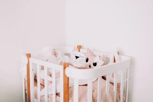 Bir kız bebek için tatlı kreş odası süslemeleri. Renkli dekoratif yastıklar ile İskandinav tarzında rahat çocuk yatak odası. — Stok fotoğraf