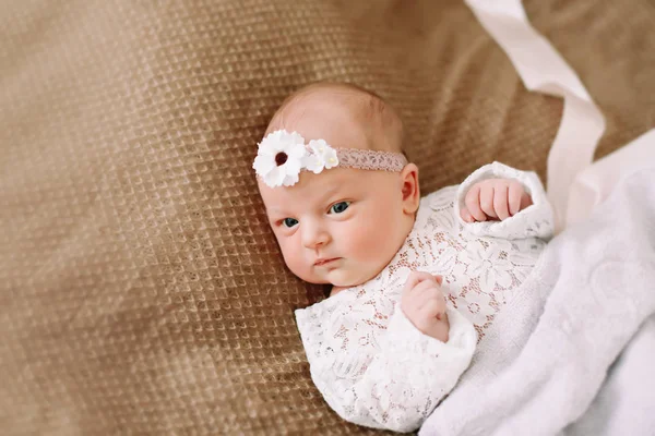 特写可爱的新生女婴在毯子上。一个美丽的新生儿戴着头带的肖像。特写照片 — 图库照片