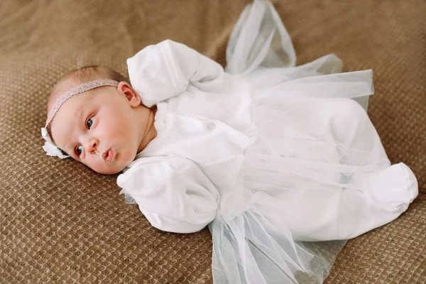 Primo piano bella neonata su una coperta. Un ritratto di una bellissima neonata che indossa un cerchietto. Primo piano foto — Foto Stock