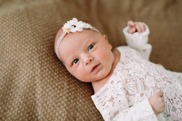 Primer plano encantadora niña recién nacida en una manta. Un retrato de una hermosa niña recién nacida con una diadema. Foto de primer plano —  Fotos de Stock