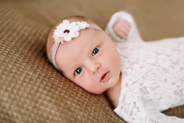 Close-up mooie pasgeboren baby meisje op een deken. Een portret van een mooie pasgeboren baby meisje het dragen van een hoofdband. Close-up foto — Stockfoto