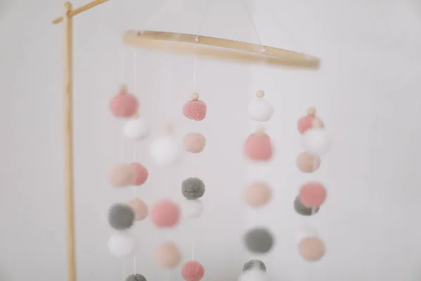 Detalles de la habitación del bebé recién nacido. Juguetes por encima de la cuna. Carrusel colgante de bolas de colores suaves para el niño . — Foto de Stock