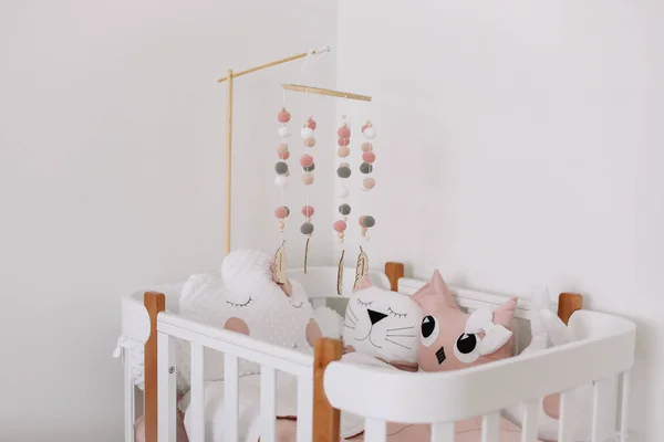 Beautiful interior of baby room. White crib with pillows and pink blanket in baby room.  pink bedding on bed against white wall — Stock Photo, Image