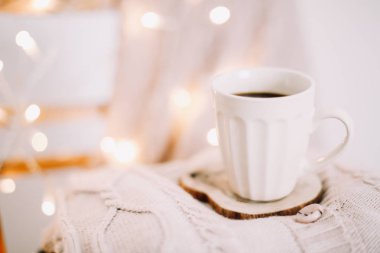 Arka planda bir örgü bej ekose ile kahve fincan üst görünümü. Sonbahar ve kış, eğlence konsepti. Düz yatıyordu