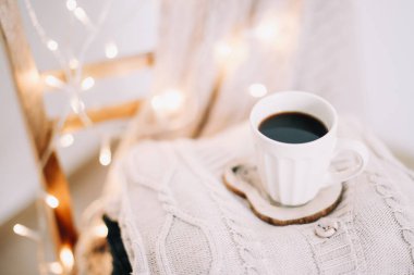 Arka planda bir örgü bej ekose ile kahve fincan üst görünümü. Sonbahar ve kış, eğlence konsepti. Düz yatıyordu