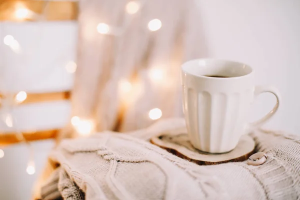 Вид сверху чашки кофе на фоне вязаного бежевого пиджака. Осень и зима, досуг. Плоский лежал — стоковое фото