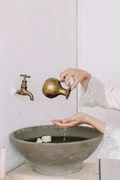 Çiçekleri eski bir lavaboda suyla tutan bir kızın elleri. Retro taşlanmış leğen. — Stok fotoğraf