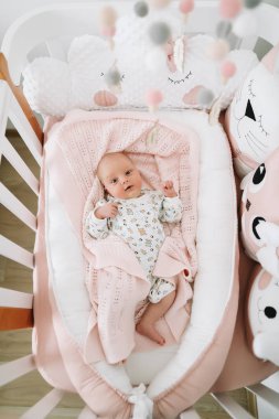 Battaniyenin üstünde yeni doğmuş güzel bir kız bebek. Yeni doğmuş güzel bir bebeğin portresi. Yeni doğmuş kız yatakta. Doğumdan hemen sonra sağlıklı bir bebek..