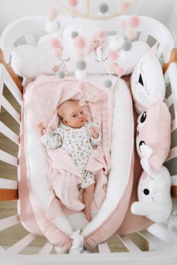 Battaniyenin üstünde yeni doğmuş güzel bir kız bebek. Yeni doğmuş güzel bir bebeğin portresi. Yeni doğmuş kız yatakta. Doğumdan hemen sonra sağlıklı bir bebek..