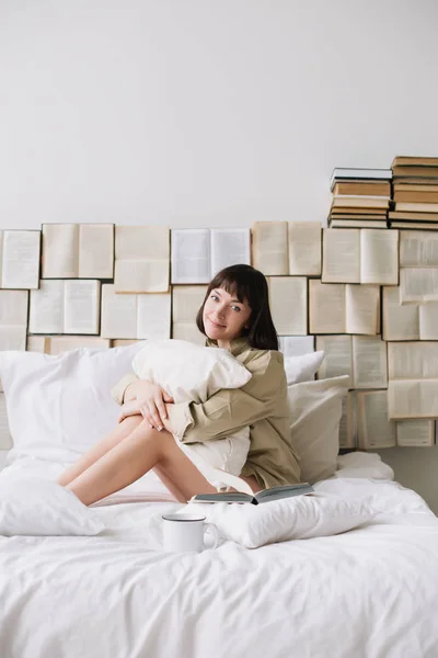 Retrato de uma jovem mulher bonita na cama em casa. Linda jovem morena no quarto. Bom dia. Estilo de vida . — Fotografia de Stock